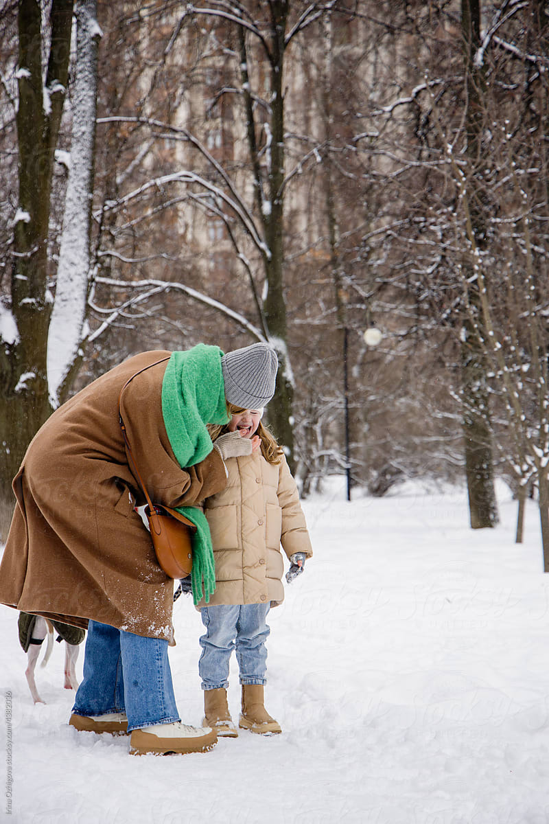 Mom taking care of child in snowy park