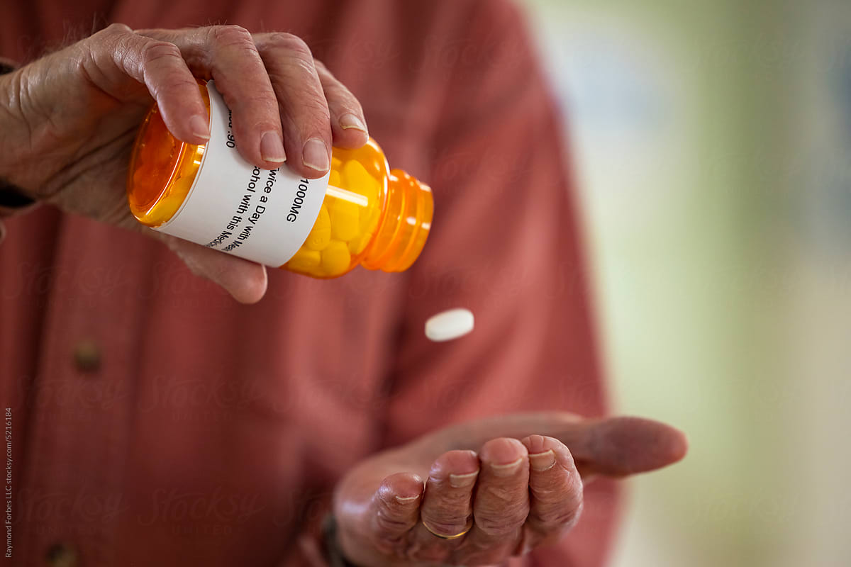 Retired Senior Citizen with prescription pill falling in hand