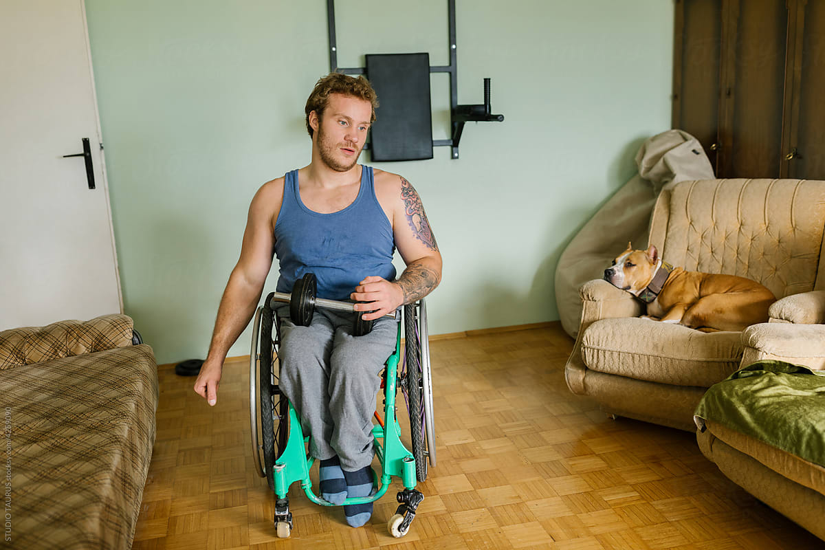 Man In A Wheelchair Doing Exercises At Home