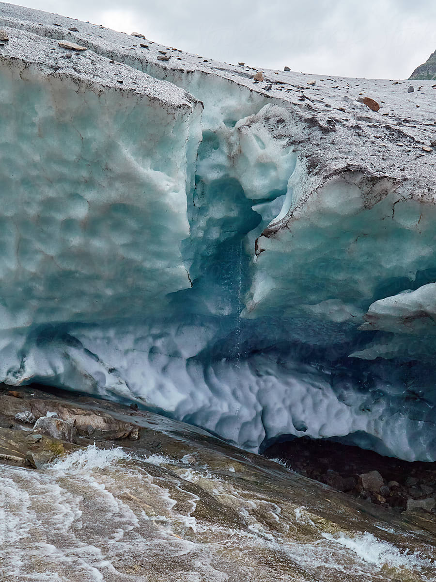 Melting ice water dripping from glacier in summer heatwave, Swiss Alps
