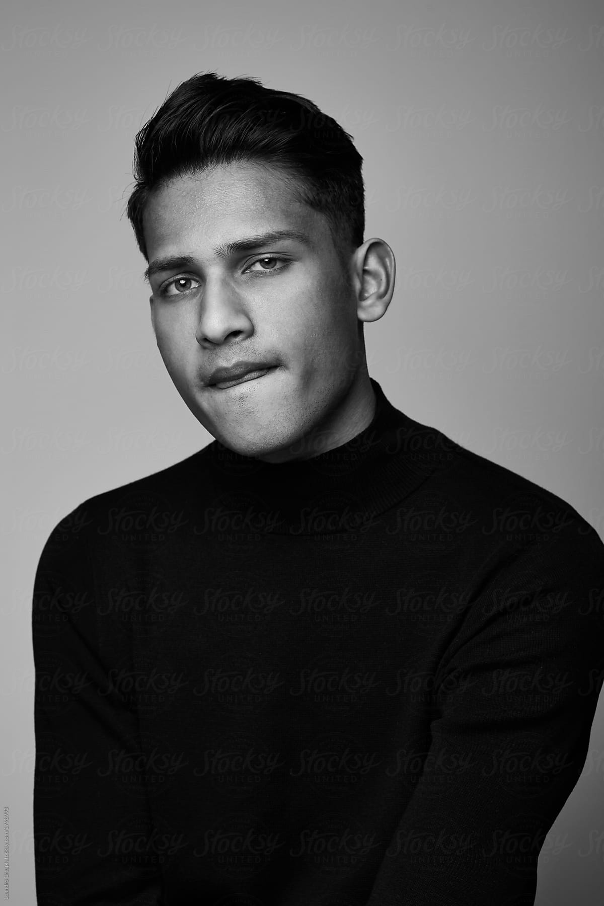 Handsome Indian guy portrait wearing turtle neck isolated on black and white