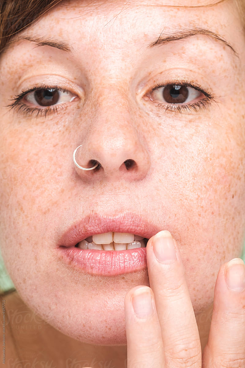 Ginger Woman With Freckles Applying Lip Balm Close Up