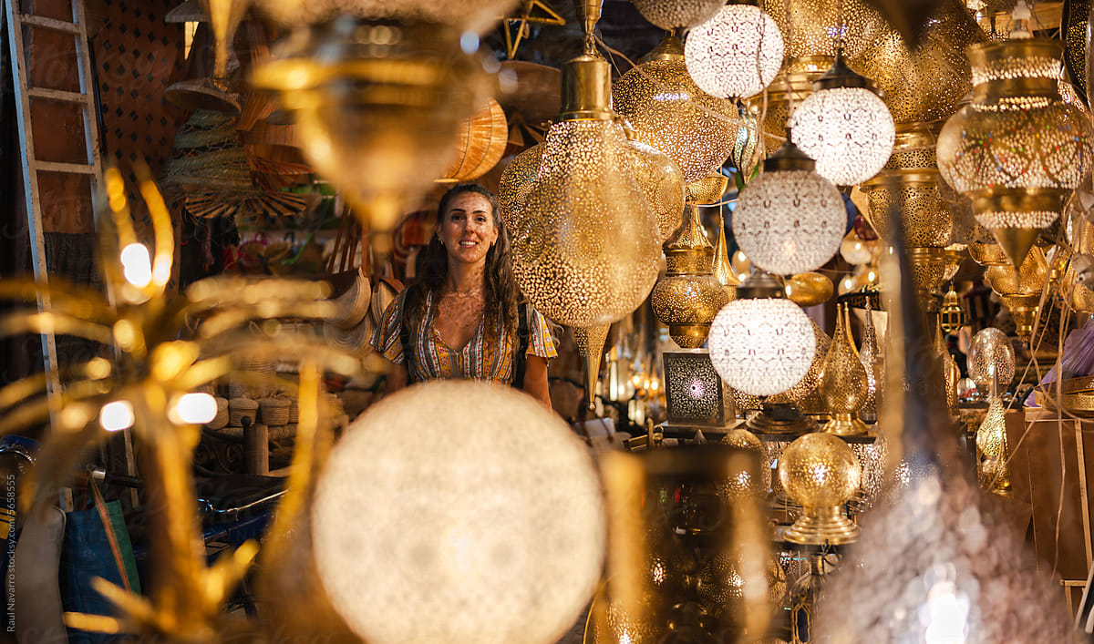 Woman in a bazaar surrounded by golden lamps