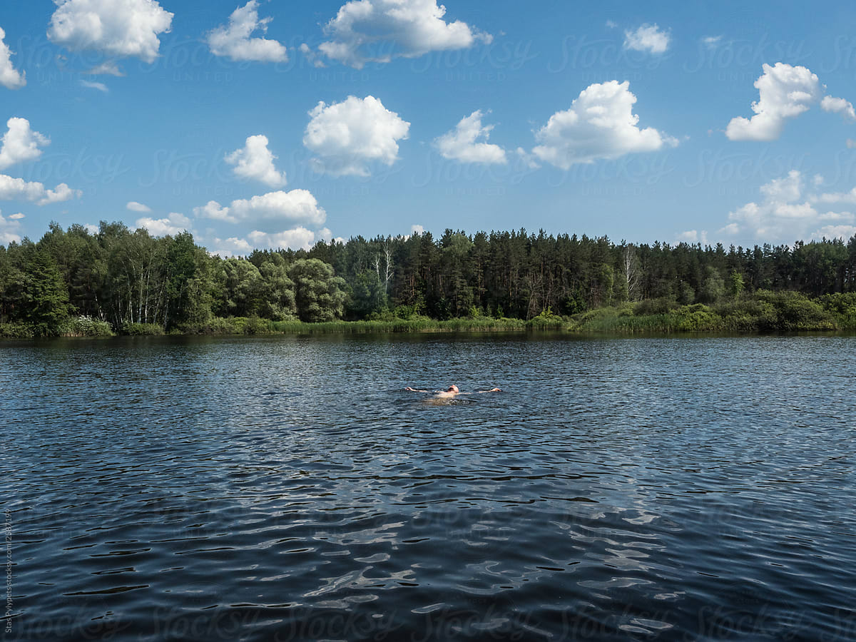 Guy swims in a lake