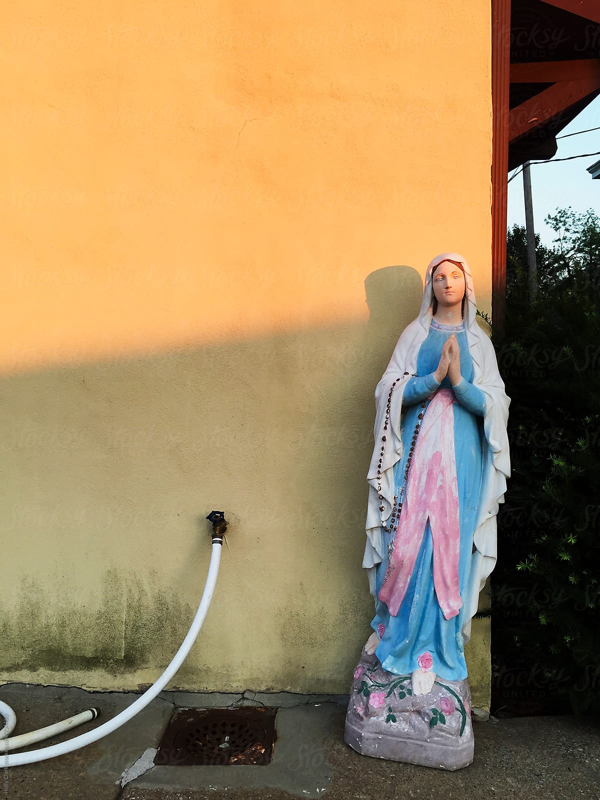 Virgin Mary statue against a dirty wall