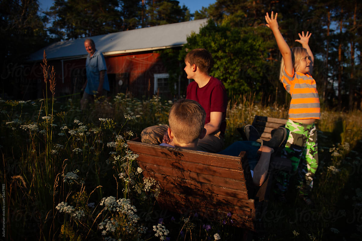 Fun moment as kids hang out in a meadow at dusk in rural Finland.