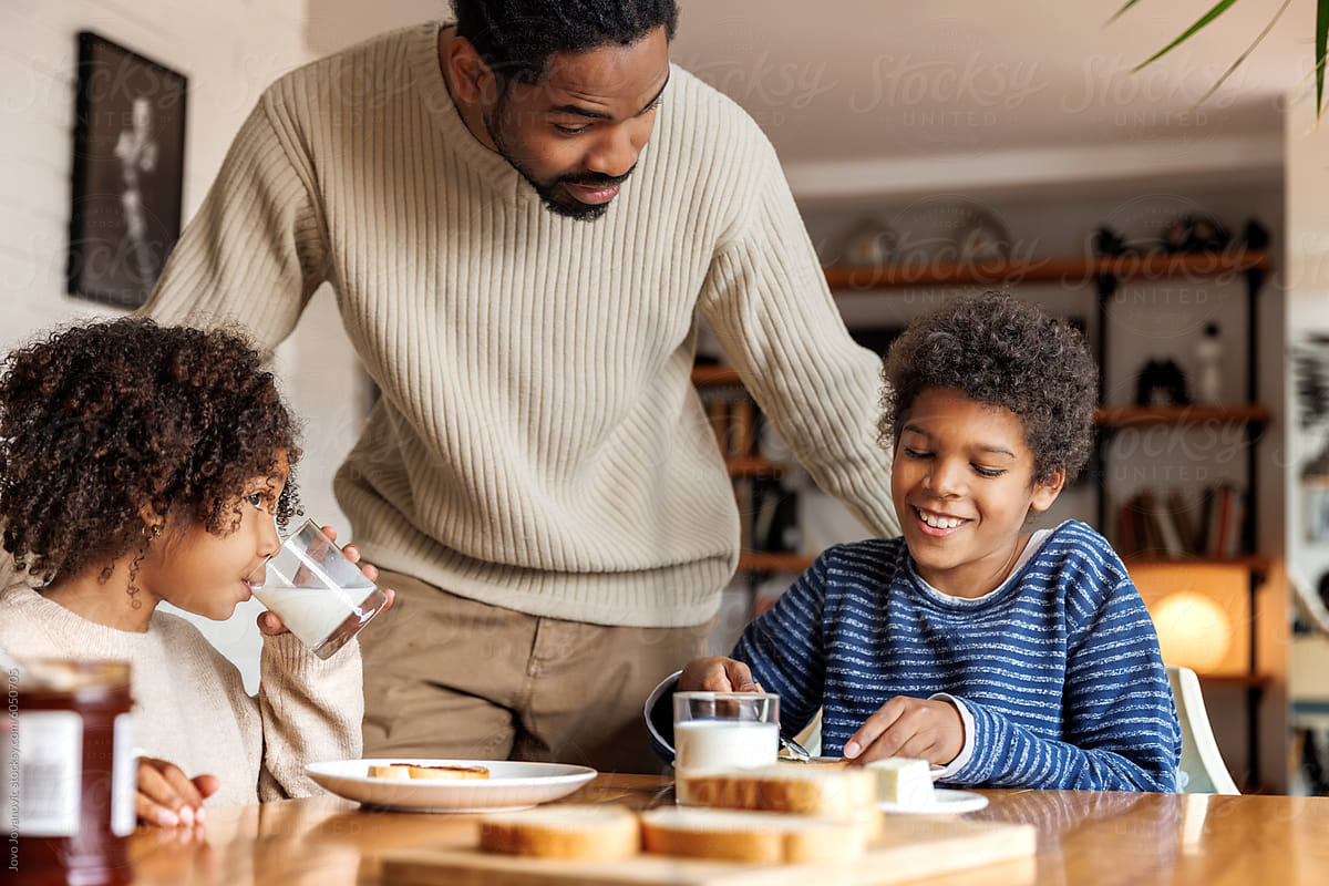 Father talking with children having breakfast