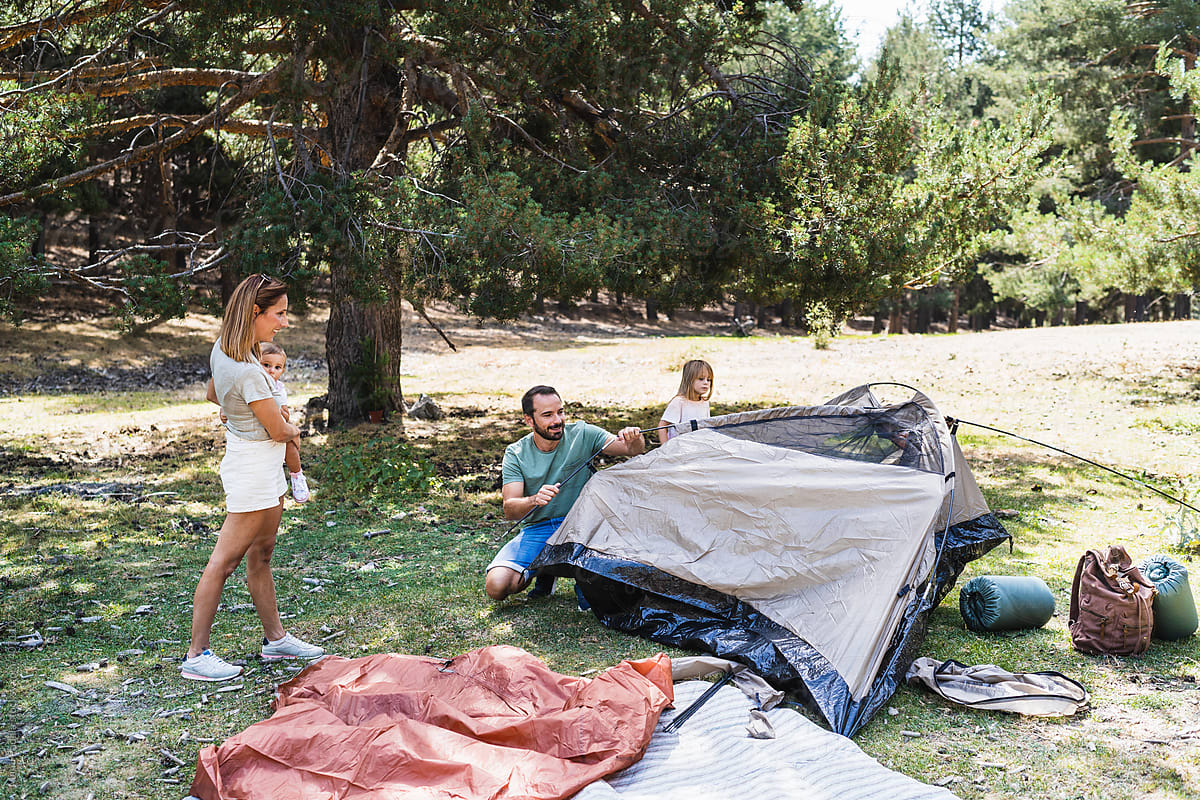 Family setting up tent in nature