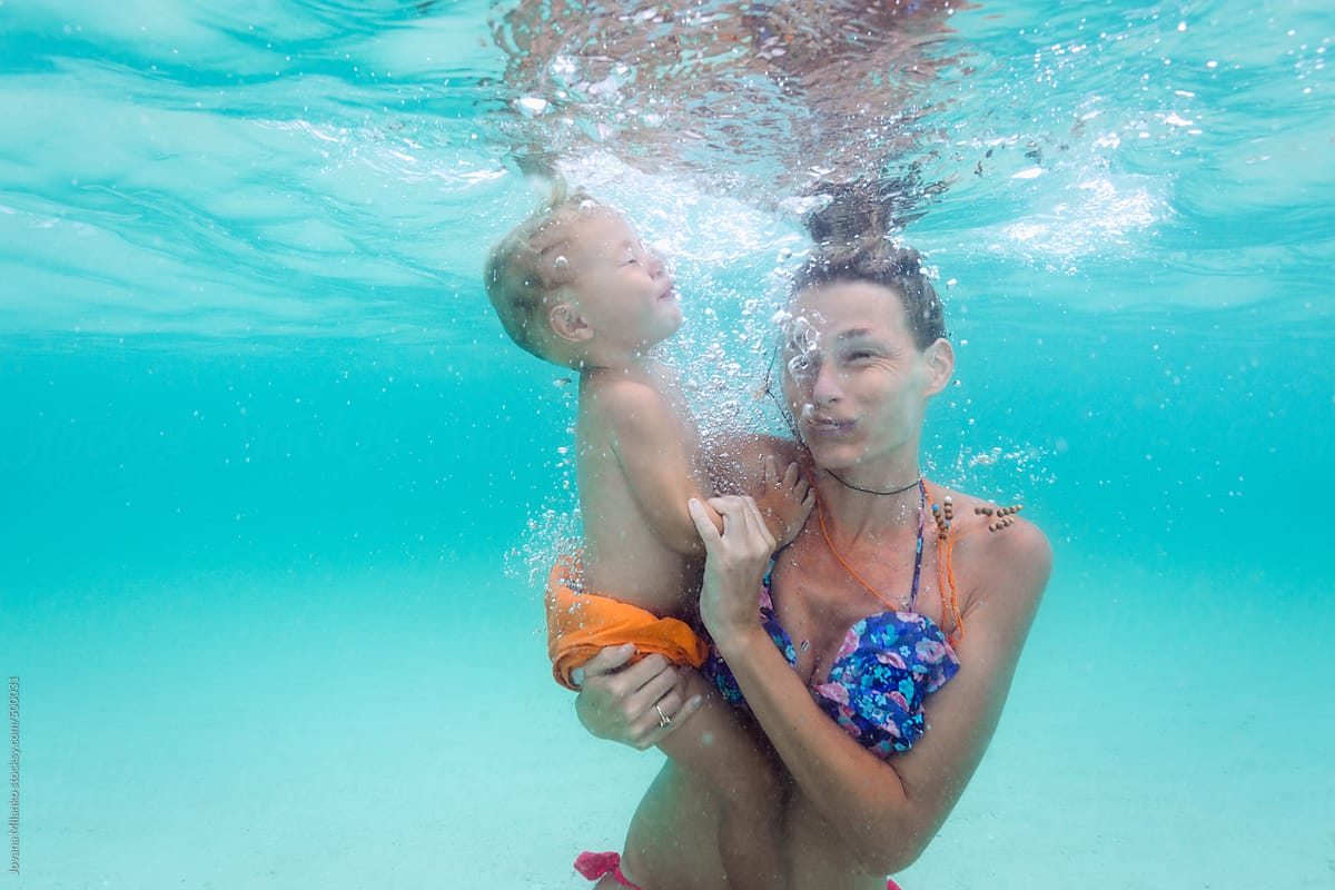 Baby boy swims underwater with his mum