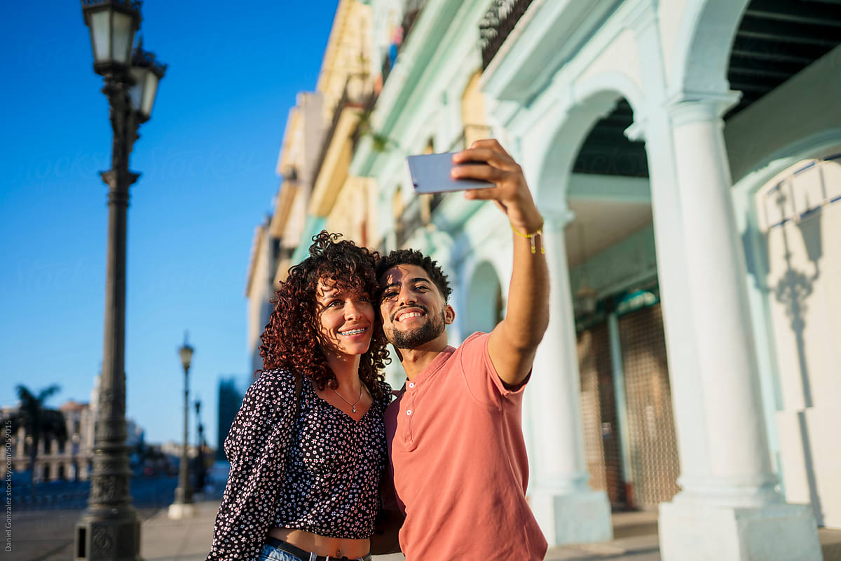 Cuban couple taking selfie on street