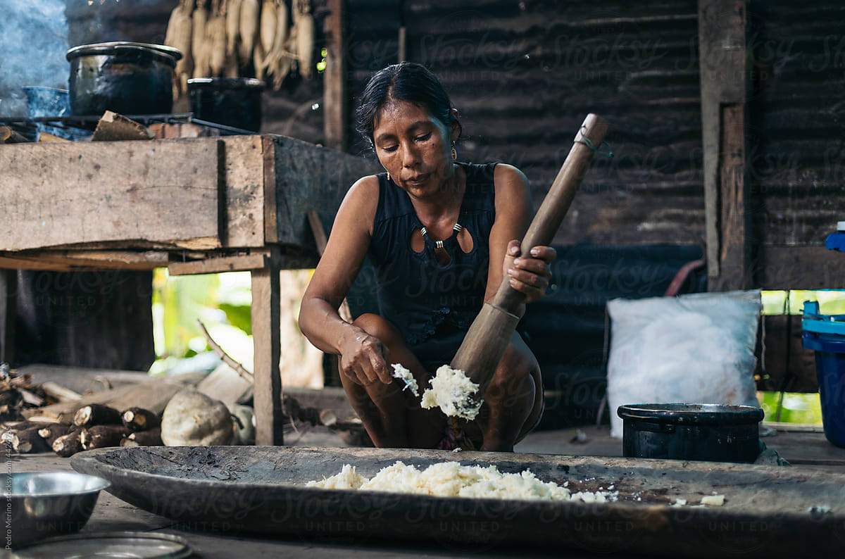 Young peruvian woman pounding yucca