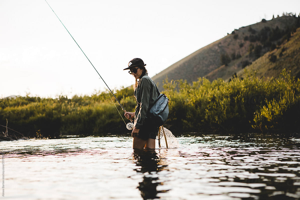 Woman Fly Fishing A Small Stream by Stocksy Contributor Aimee