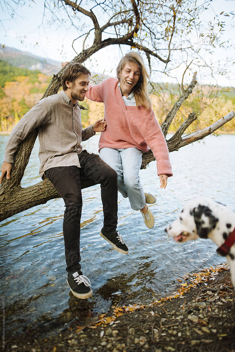 Man and woman having fun with their dog outdoors