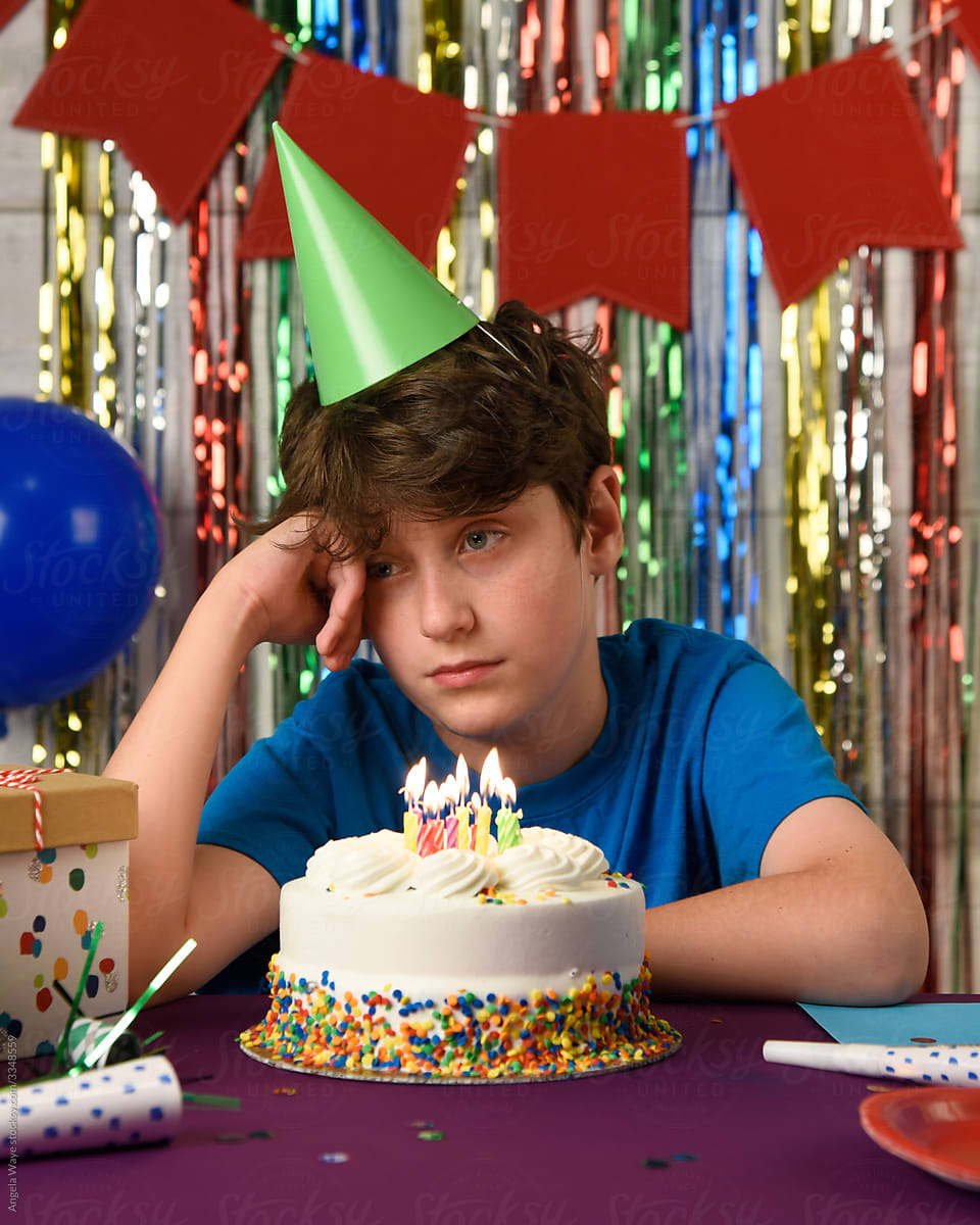 Sad Birthday Boy at Table Looking at Cake Alone