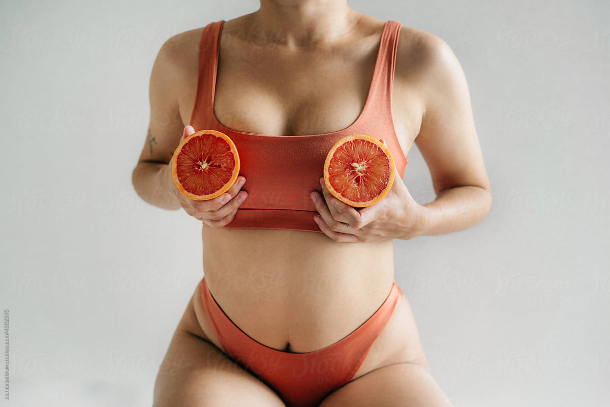 Body Of A Young Woman With To Oranges On Her Breasts by Stocksy