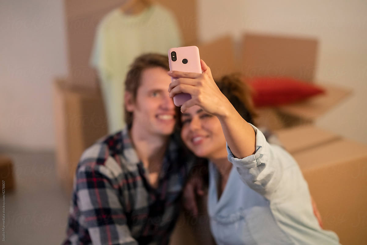 Happy couple taking selfie after relocation