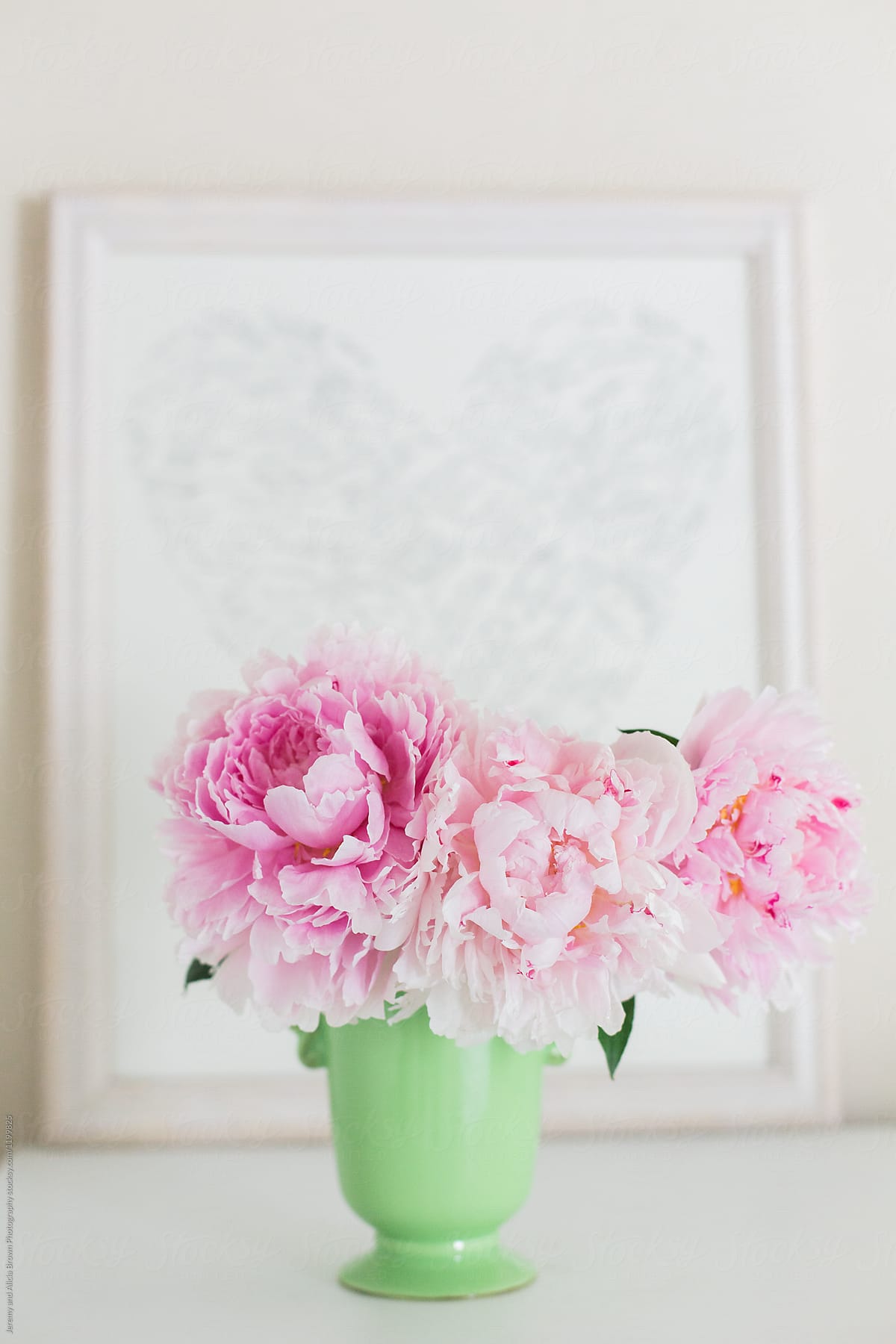 Bouquet of peonies in front of a heart print