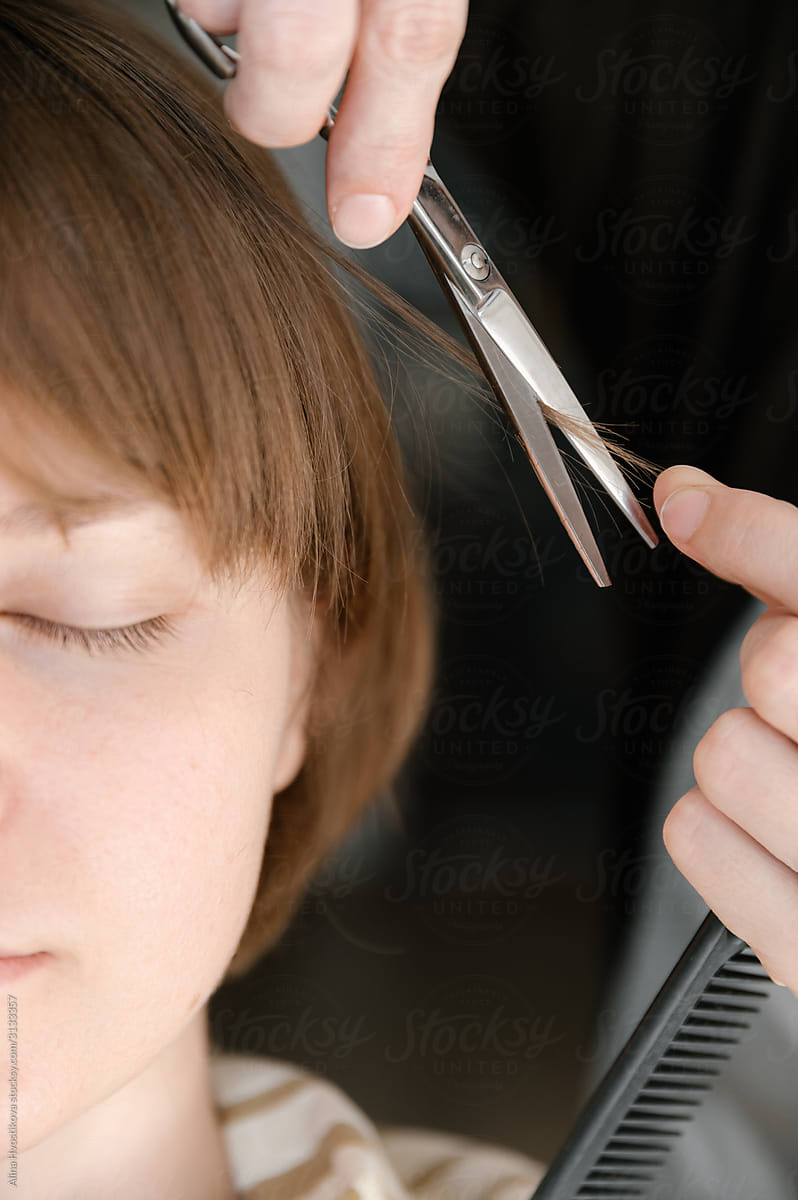 Hands hairdresser cutting hair female