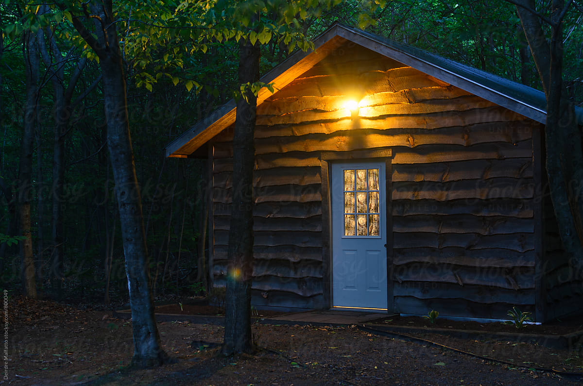 exterior of a cabin in the woods at night