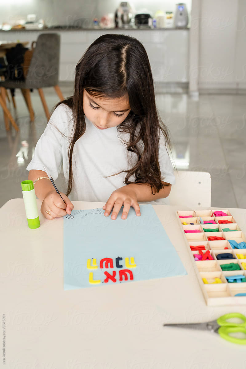Girl Creating Rosh Hashanah Word with Hebrew Letters from Box.