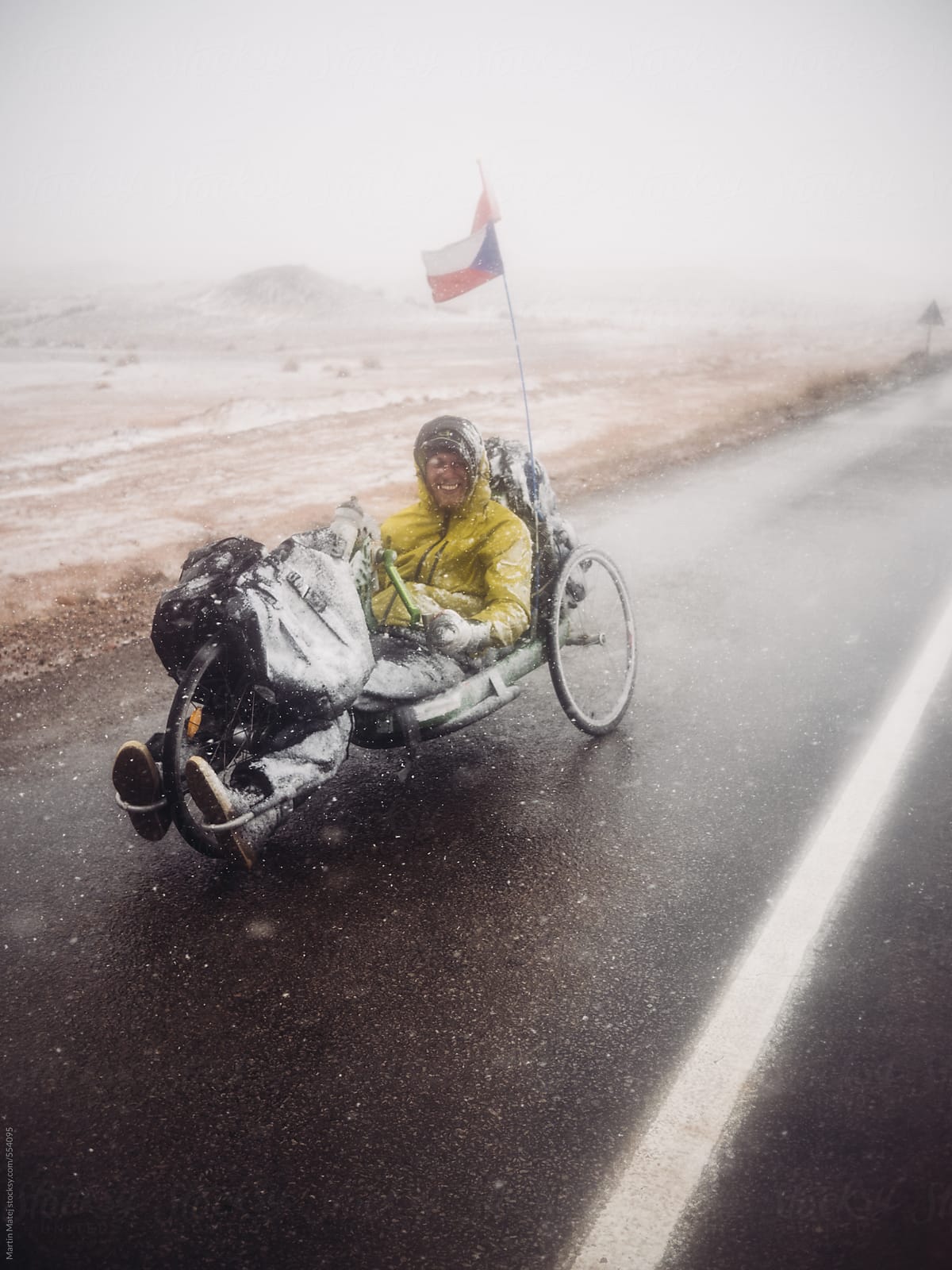 Handbiker covered in snow standing on the road