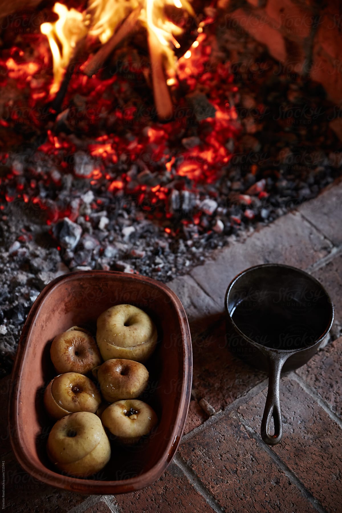 Baked apples in ceramic bowl cooked over the fire