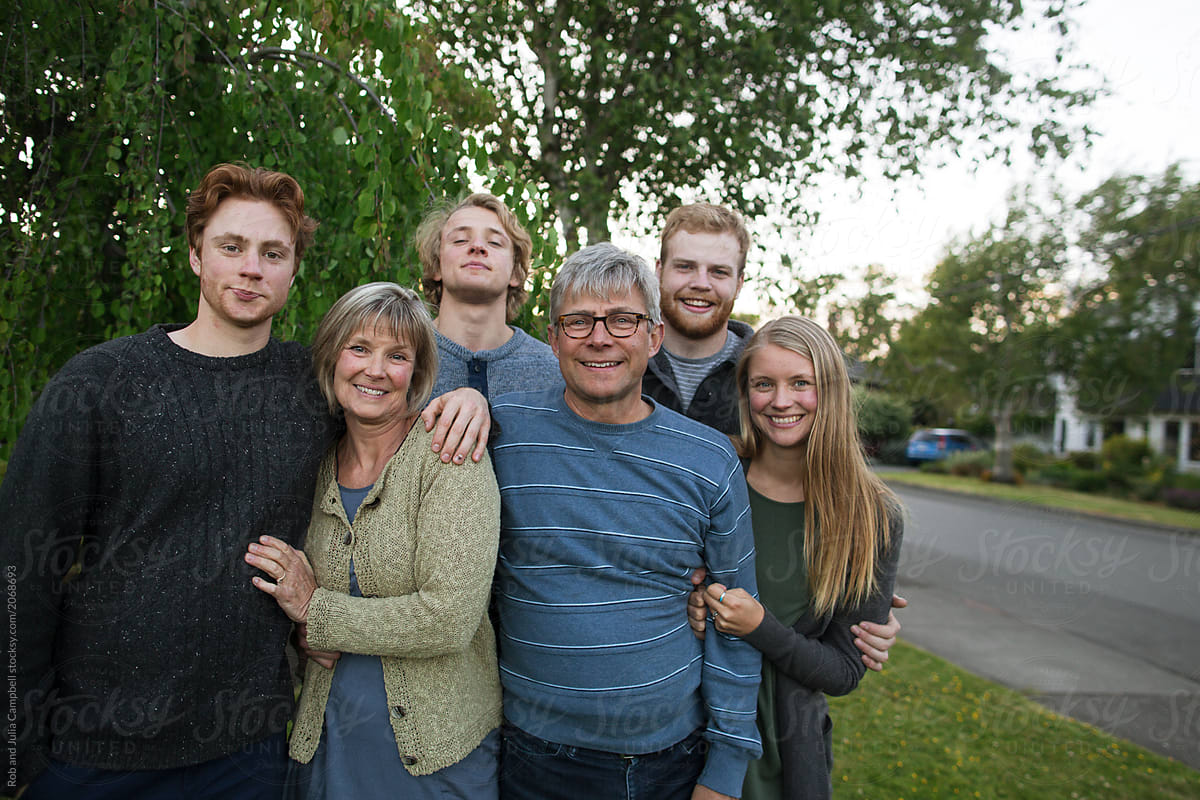 Smiling portrait of family with grown up kids outside together