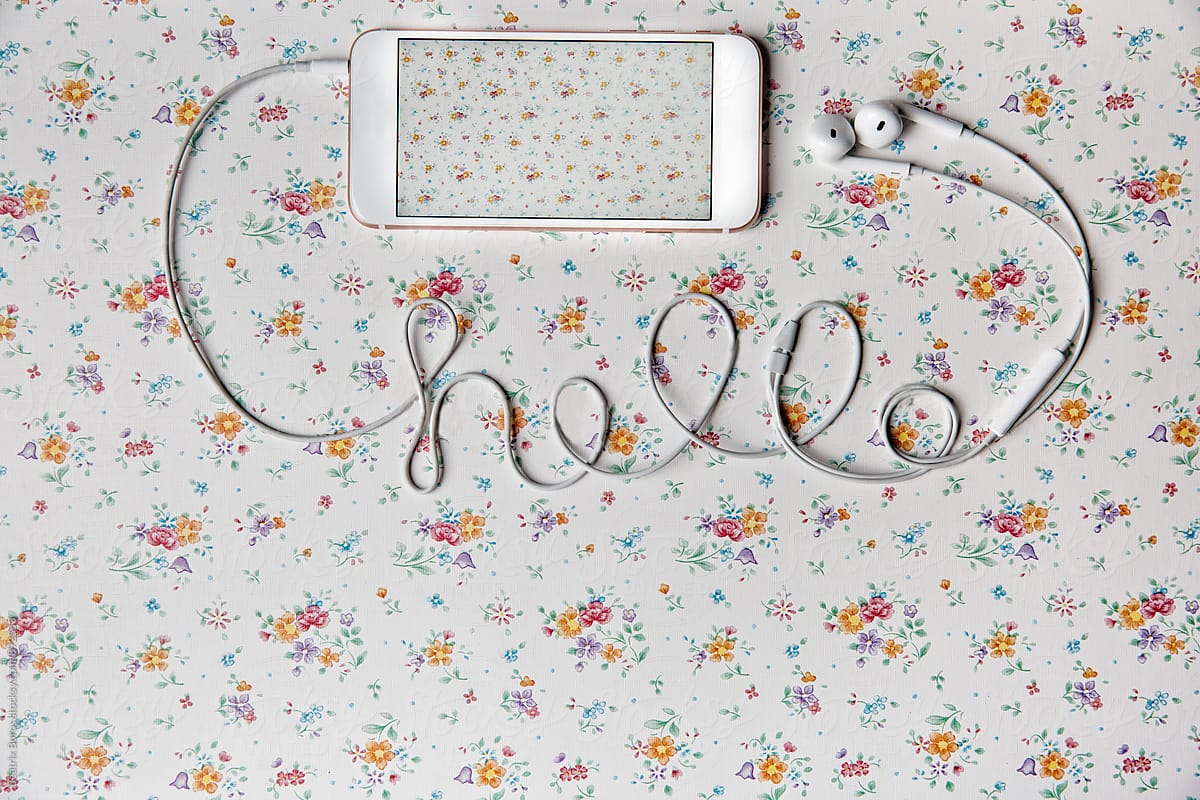 Mobile phone on a floral pattern with hello written with cable