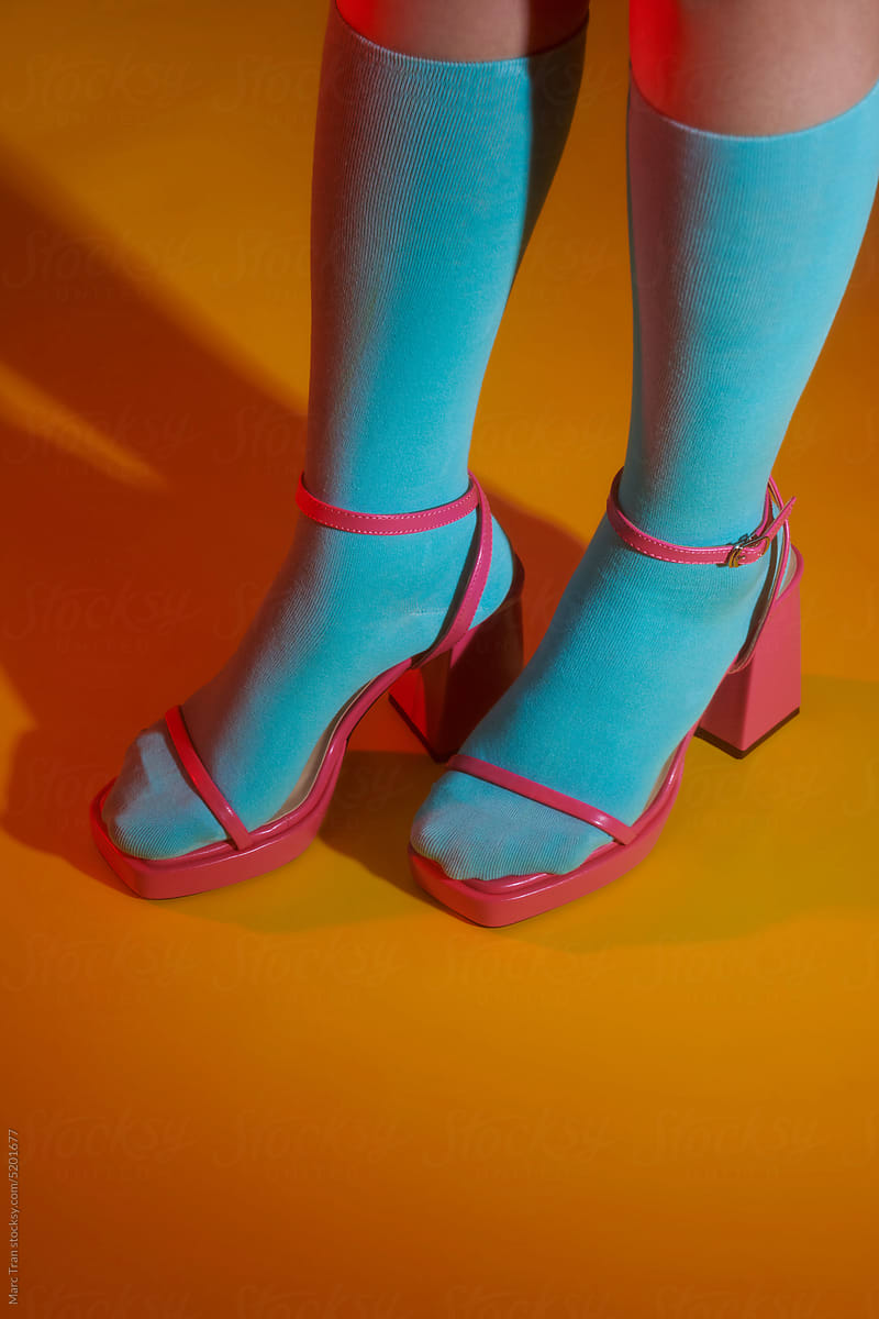 female legs in orange socks wearing pink sandals