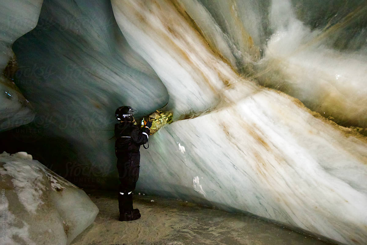 Glacier ice cave, Svalbard - caving adventure tourism, female traveller