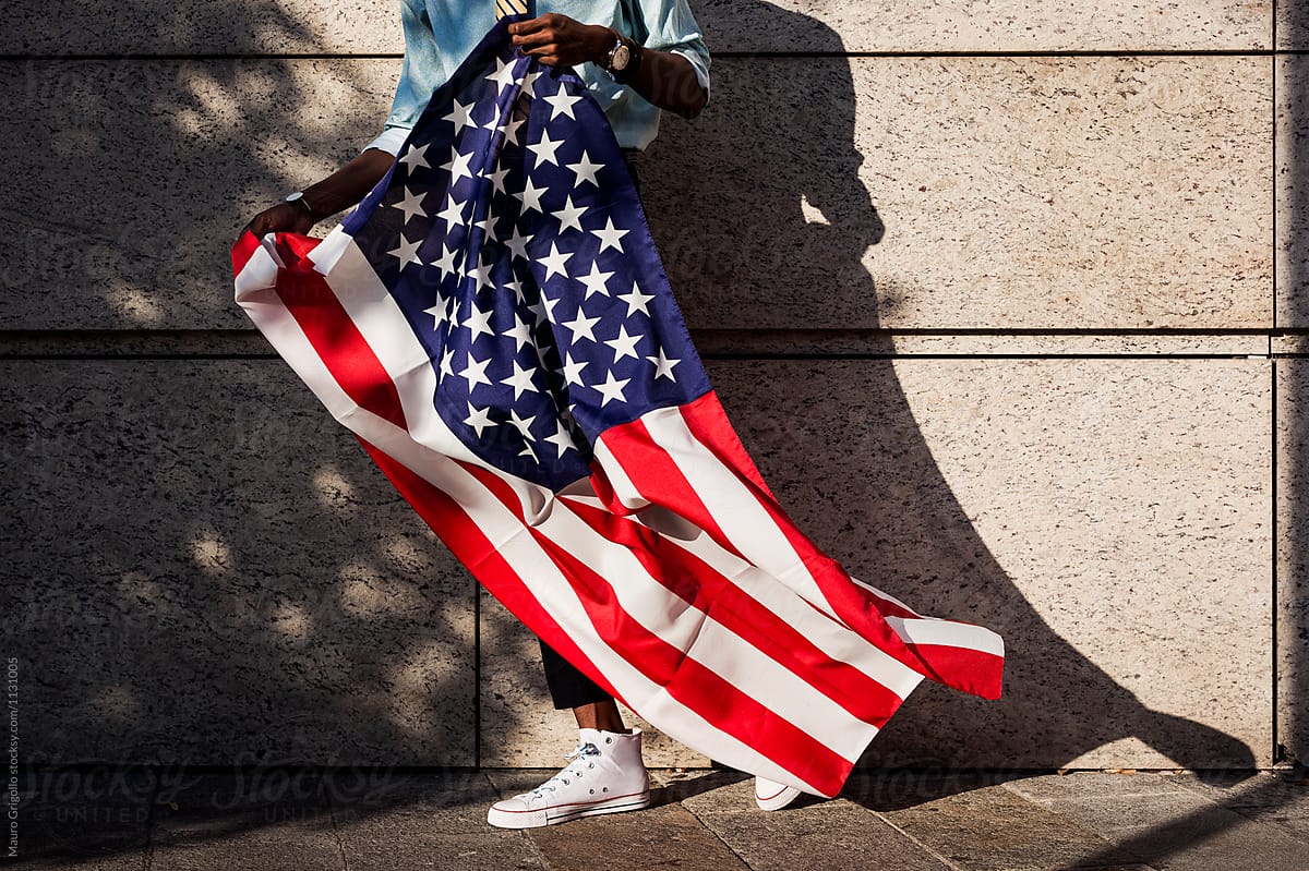 Black man holding an American flag outdoor