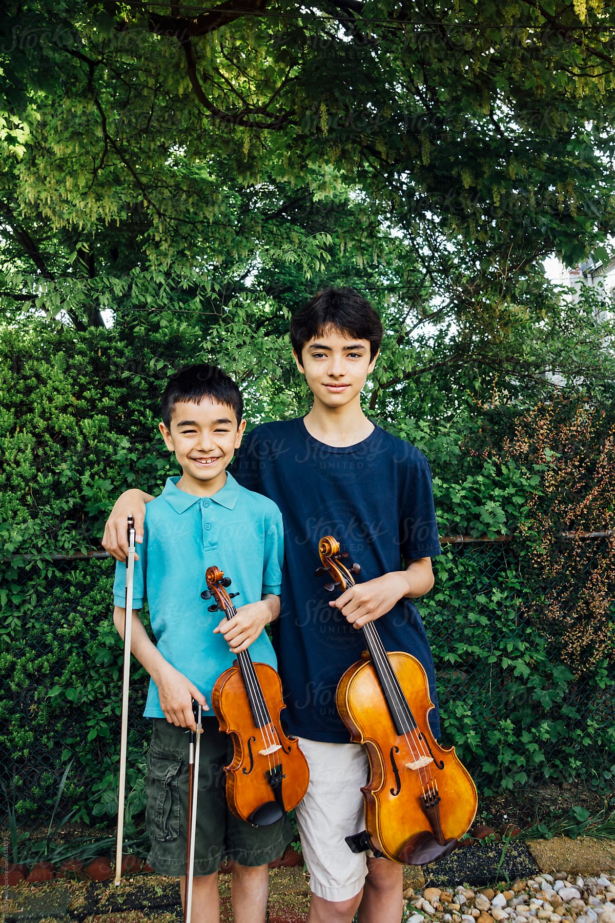 Asian brothers outdoor portrait with viola and violin