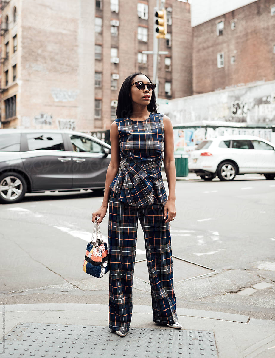 Woman in plaid suit and sequin purse walking in new York city