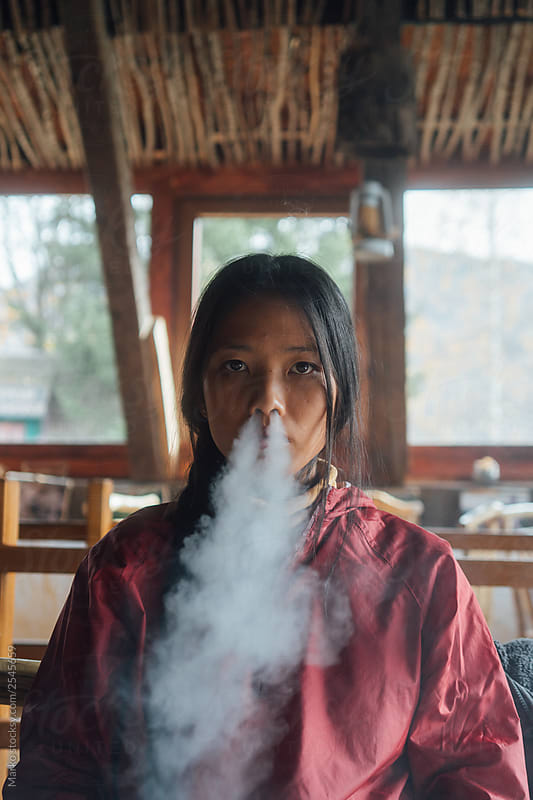 Woman Exhaling Smoke Through Nose