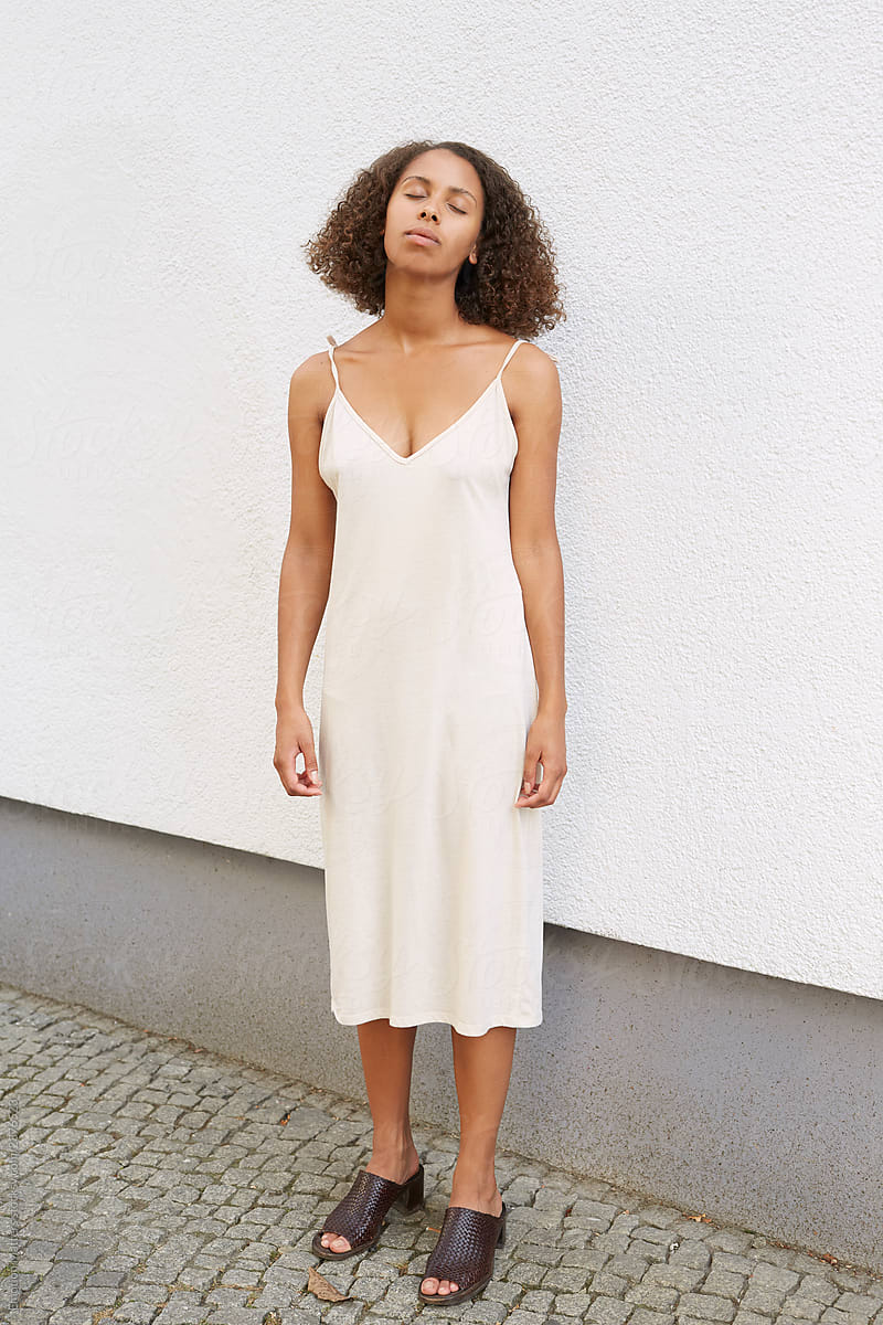 A black woman with a minimalistic cotton dress.