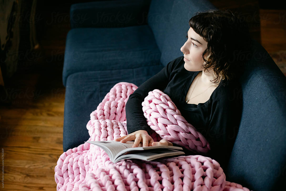 Woman Reading Book Cozily on Couch