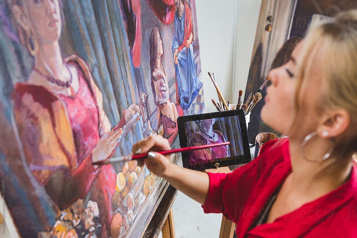 Female Artist Paints while Watching at the Tablet, Technology Helps