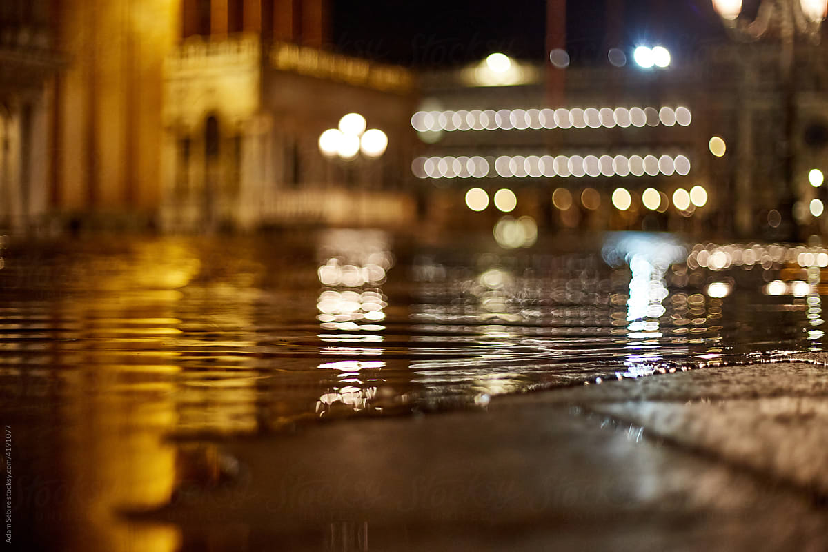 Floodwaters seep, Venice sidewalk pavement, night high tide