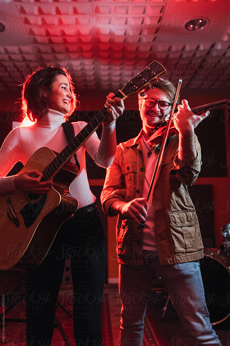 Couple playing instruments in a studio.