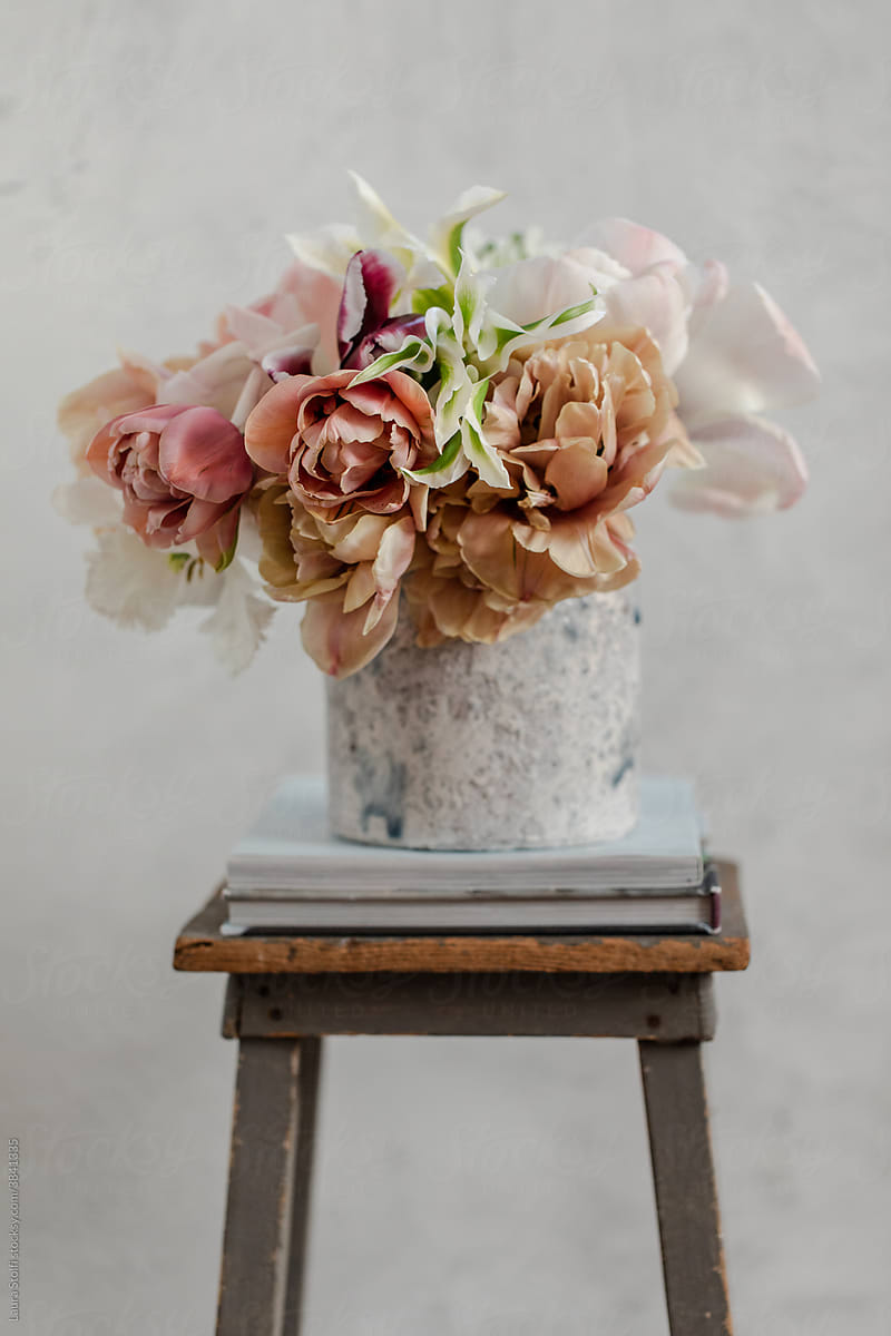Tulips in concrete vase on stool