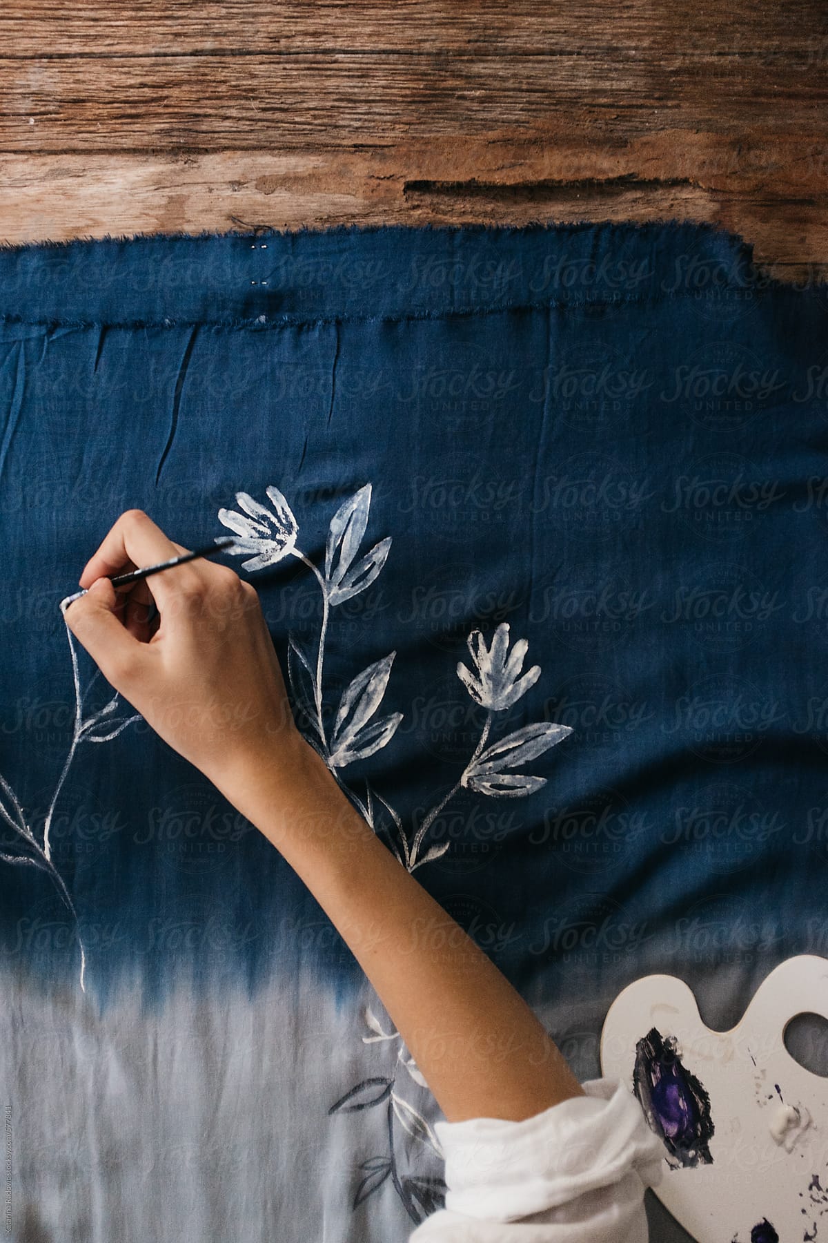 Female Artist Painting Flower Pattern on a Blue Fabric