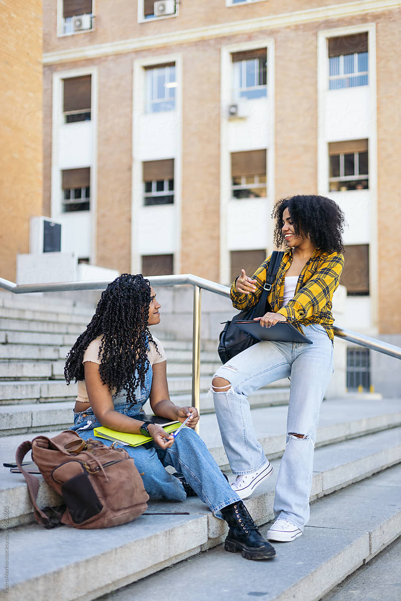 young students talking on the stairs of the university campus