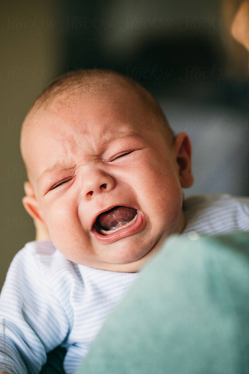 Parent comforting screaming annoyed newborn baby