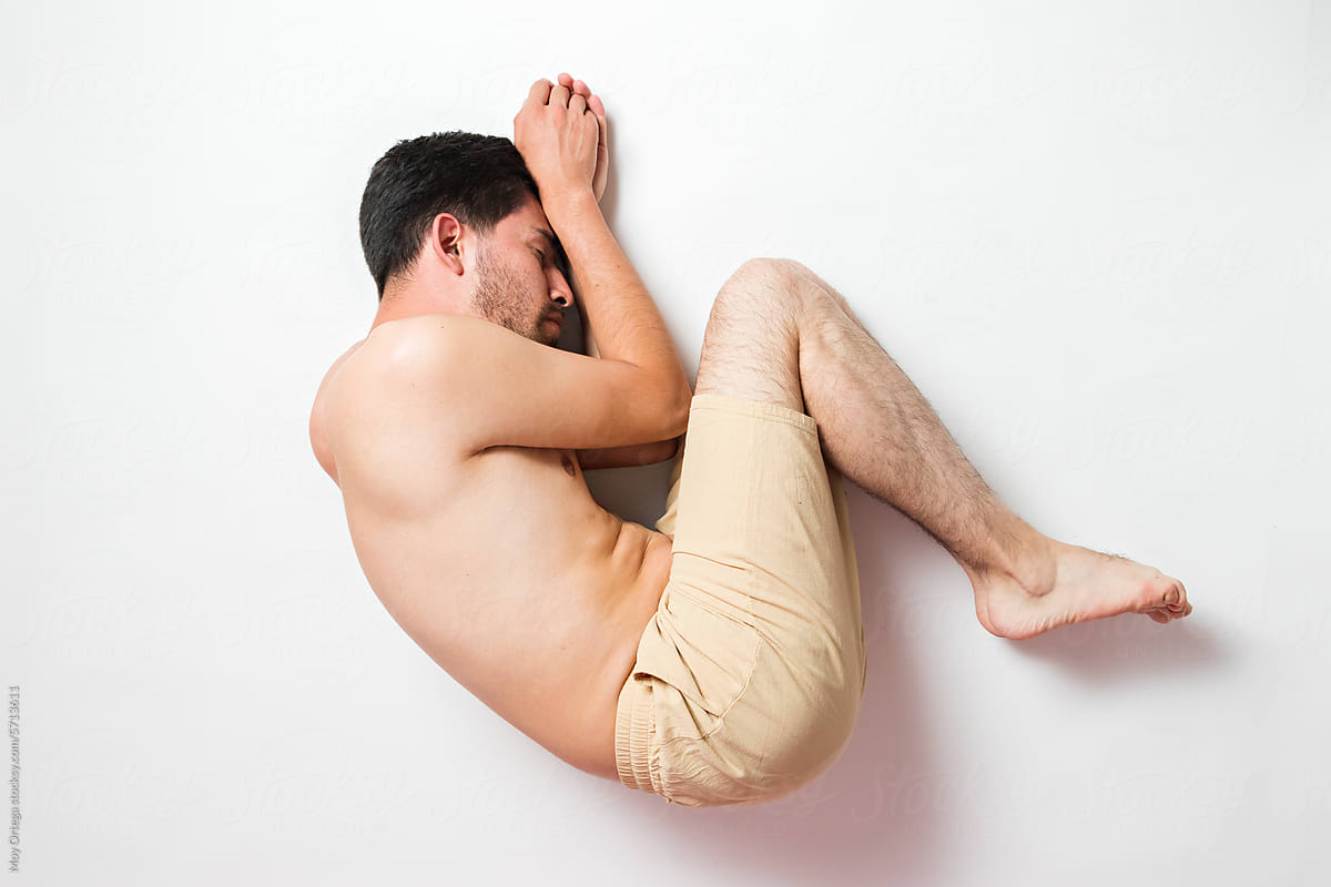 Abstract portrait of a young hairy man posing on the floor