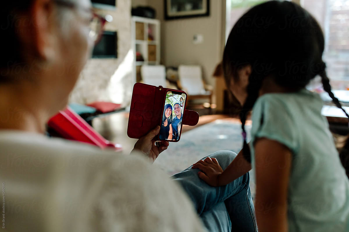 grandparent using cell phone to converse with family in video call