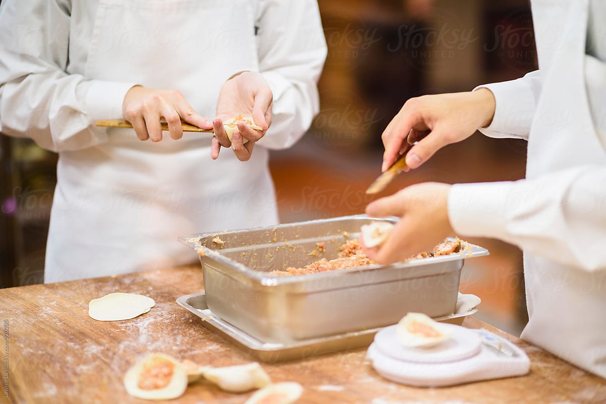 Professional cooks preparing dumpling