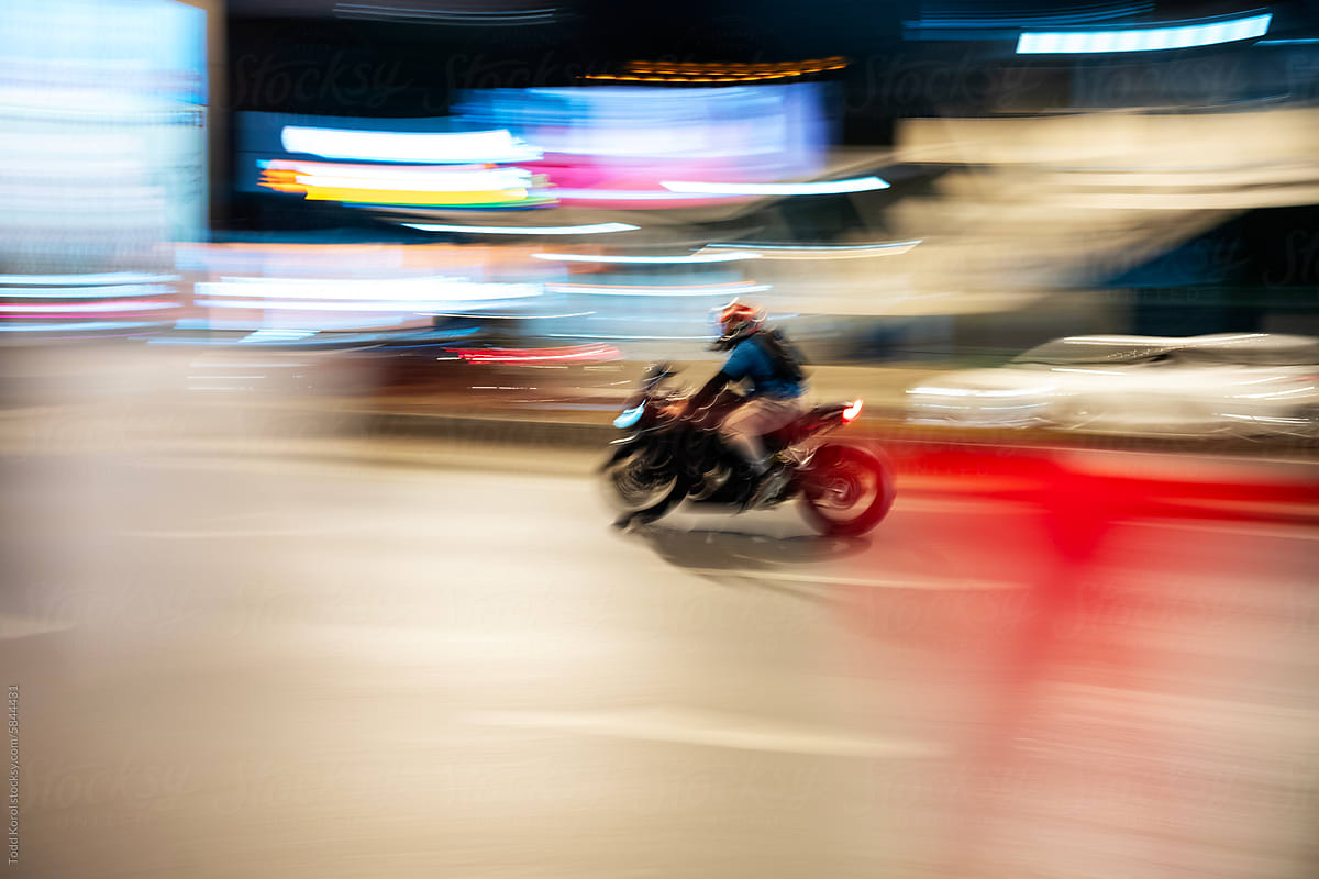 A scooter zooms through the night.