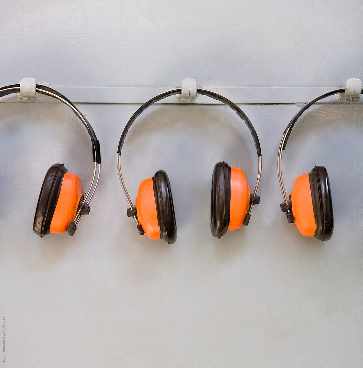 Ear defenders hanging on factory wall.