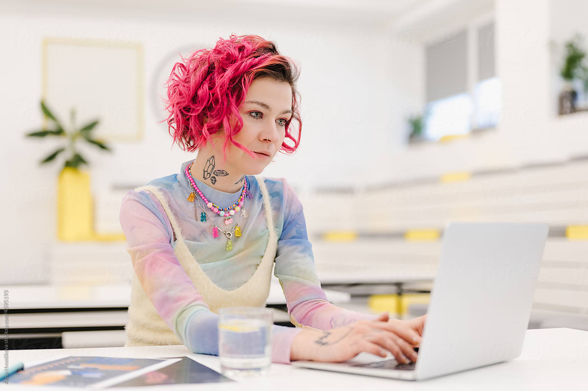 Gen Z woman working on laptop in creative office