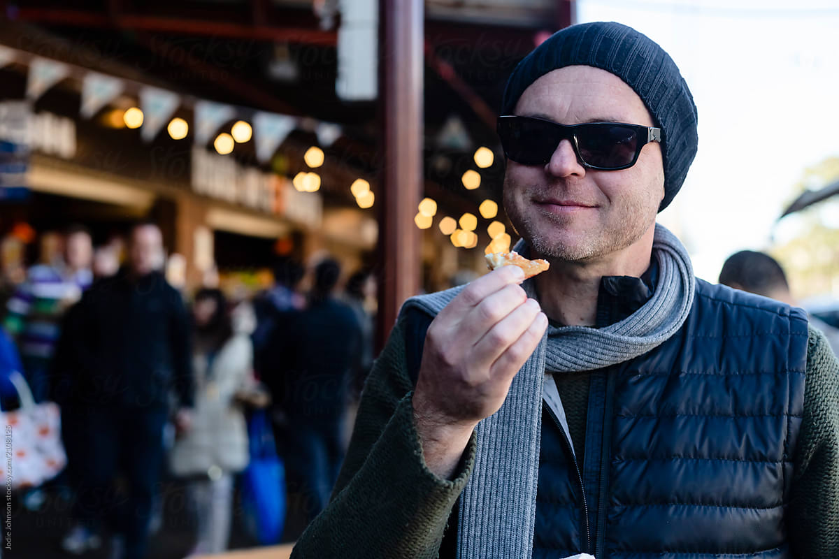 A man enjoying a donut at the market